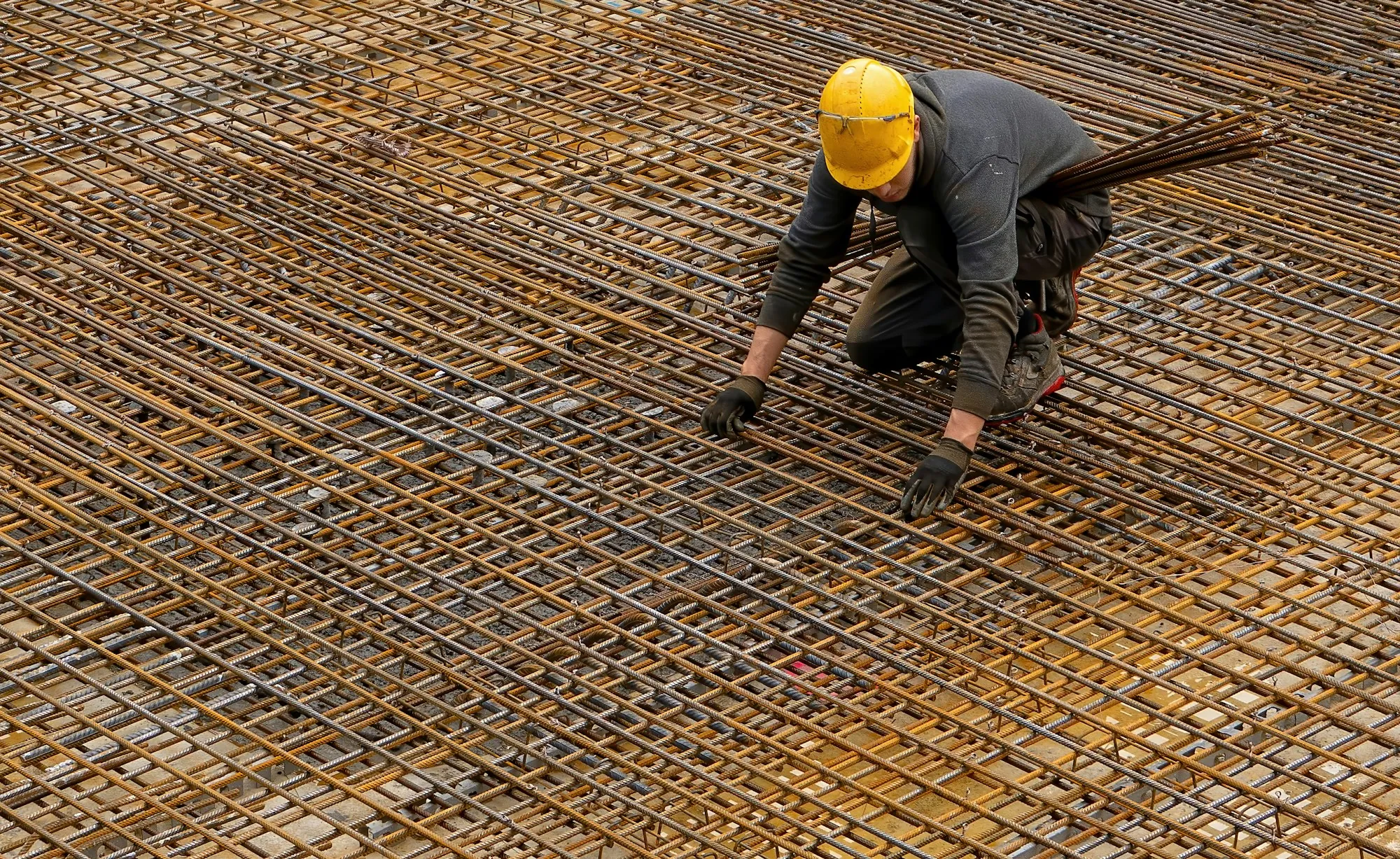 Worker tying rebar mesh for a concrete slab
